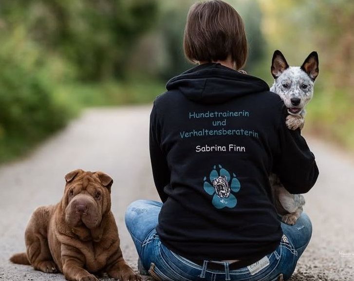 Hundetrainerin Sabrina Finn von hinten und mit zwei Hunden